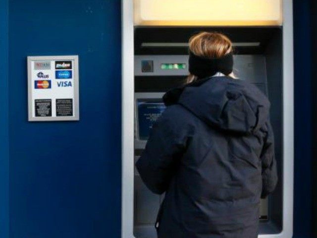 FILE - In this Jan. 5, 2013 file photo, a woman uses an ATM machine in downtown Pittsburgh