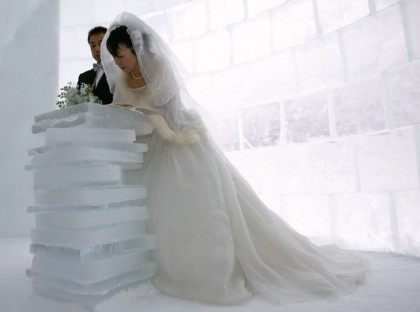Kito signs covenant as groom Matsuoka looks on during their wedding ceremony inside chapel made of ice in Shikaoi town, northern Japan