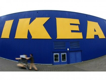 People push a shopping cart in front of a warehouse of the Swedish furniture maker IKEA in