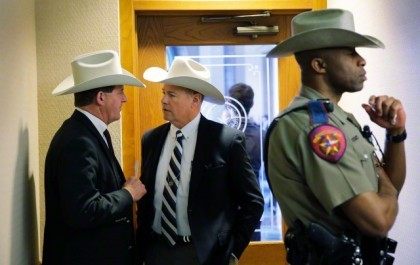 Jackson County Sheriff A.J. "Andy" Louderback, left, confers with Chambers County Sheriff Brian Hawtohorne, center, before giving testimony at a hearing where lawmakers discussed whether to legalize concealed handguns on college campuses and open carry everywhere else on Thursday, Feb. 12, 2015, in Austin, Texas.