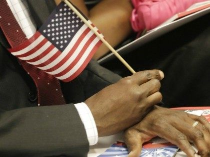 A new U.S. citizen holds an American flag during a naturalization ceremony in July. An Ari