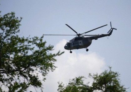 A Mexican Navy helicopter flies overhead during a search for human remains on a river near