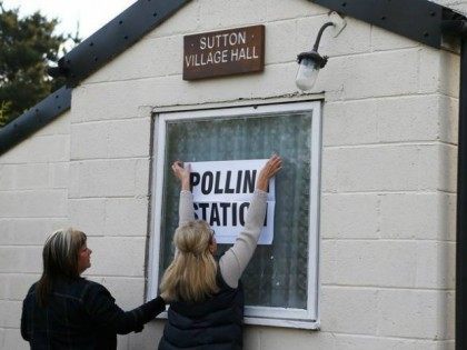 Electoral workers put up a sign in the window of a building being used as a polling station in Doncaster