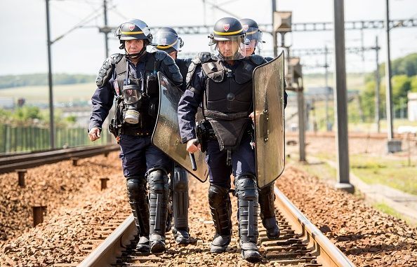 French riot police officers take position to drive out protesting French employees (unseen) of the company English Channel passenger and freight ferry company "MyFerryLink", who block the railway tracks of the Eurostar Channel tunnel line, on June 23, 2015 in Calais, northern France. Eurotunnel said that train services had been …