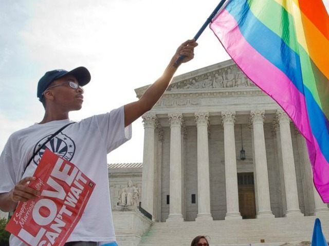 Carlos McKnight holds up a flag in support of gay marriage outside of the Supreme Court in Washington, June 26, 2015.