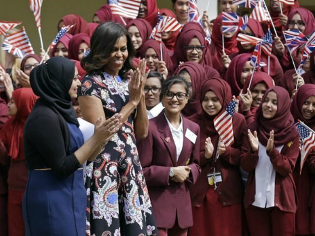 U.S. first lady Michelle Obama is greeted by pupils as she arrives at Mulberry School for
