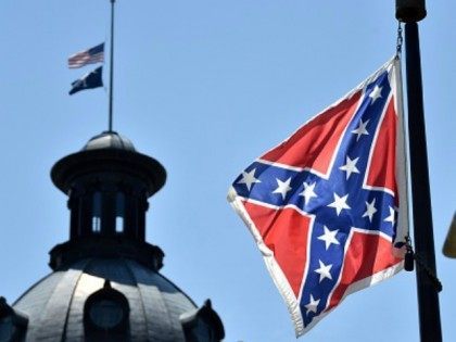 The South Carolina and American flags flying at half-staff behind the Confederate flag erected in front of the State Congress building in Columbia, South Carolina on June 19, 2015. Police captured the white suspect in a gun massacre at one of the oldest black churches in Charleston in the United …