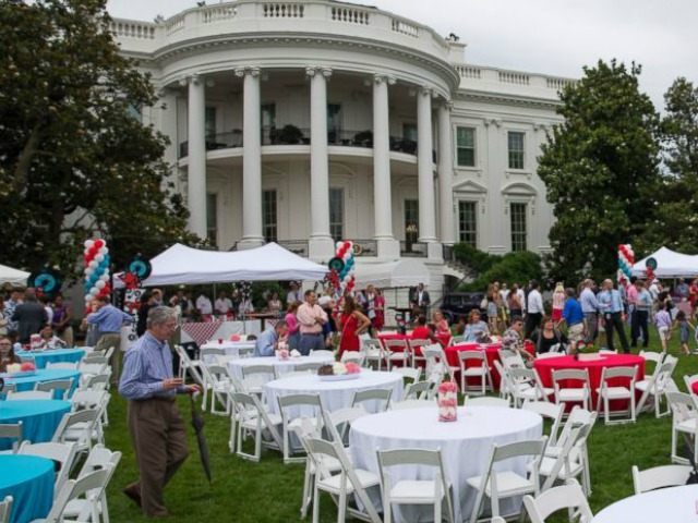 Guests take photos during a picnic for members of Congress on the South Lawn of the White