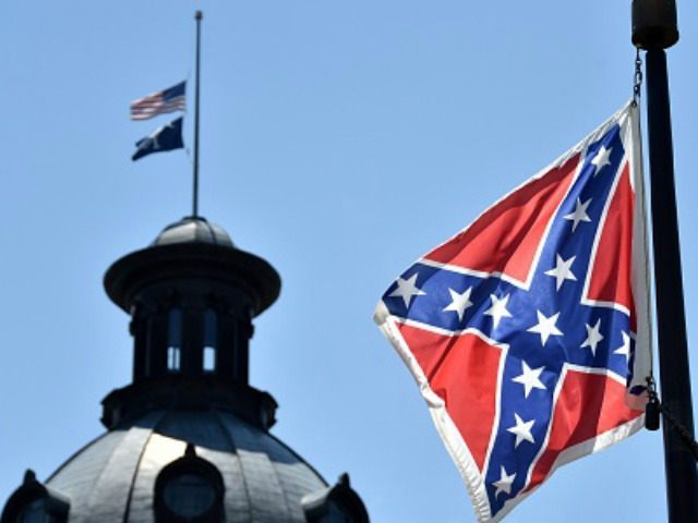 The South Carolina and American flags flying at half-staff behind the Confederate flag ere