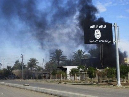 smoke-raises-behind-an-islamic-state-flag-after-iraqi-security-forces-and-shiite-fighters-