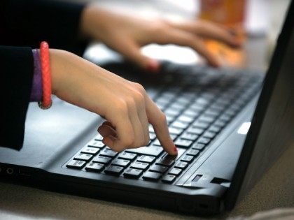 A pupil uses a laptop computer during a english lesson at the Ridings Federation Winterbourne International Academy in Winterbourne near Bristol on February 26, 2015 in South Gloucestershire, England.