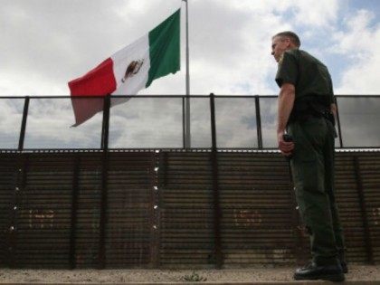 U.S. Border Patrol agent Jerry Conlin stands on the American side of the U.S.-Mexico border fence on October 3, 2013 at San Ysidro, California. While hundreds of thousands of government workers were furloughed due to the federal shutdown, thousands of Border Patrol agents, air-traffic controllers, prison guards and other federal …