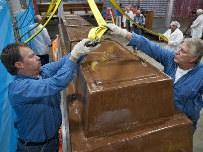 Garry Hine, left, and Gary Wychocki help move a giant chocolate bar to a scale Tuesday, Sept. 13, in Chicago.