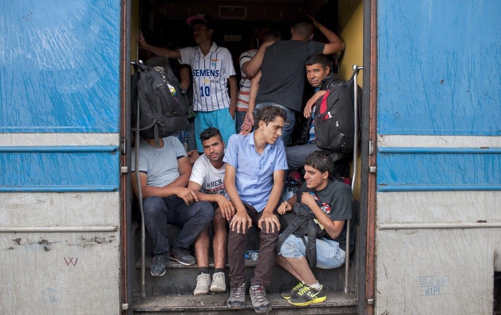Migrants look out from a coach footboard at a train station in Veles, central Macedonia, on June 20 (ROBERT ATANASOVSKI/AFP/Getty Images)