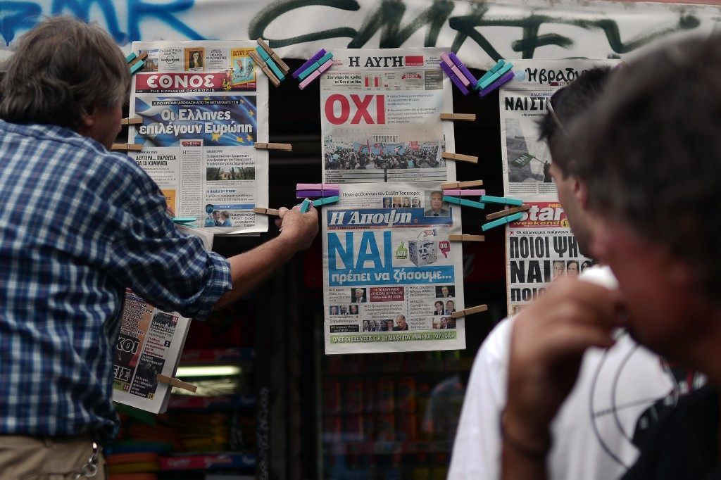 A newsagent hangs newspapers bearing "No" and "Yes" headlines in central Athens. LOUISA GOULIAMAKI/AFP/Getty Images