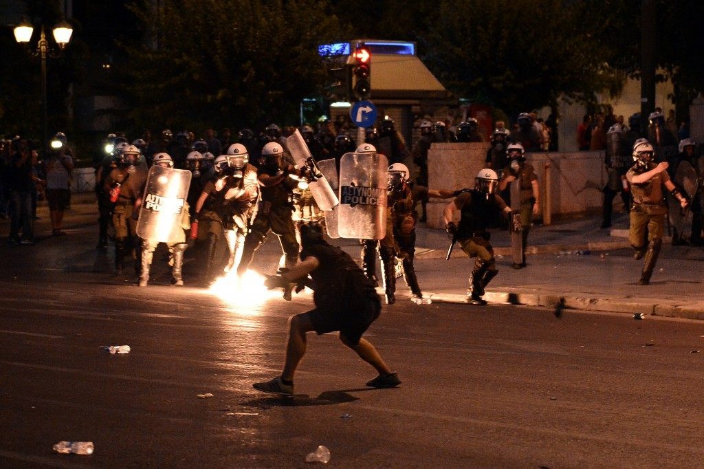 A protester hurls a petrol bomb at riot police (LOUISA GOULIAMAKI/AFP/Getty Images)