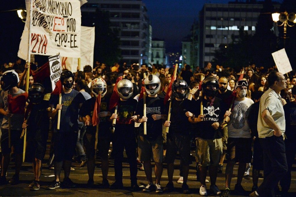 Protesters stand  in front of the Greek parliament (LOUISA GOULIAMAKI/AFP/Getty Images)