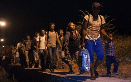 Migrants walk on train tracks (ROBERT ATANASOVSKI/AFP/Getty Images)