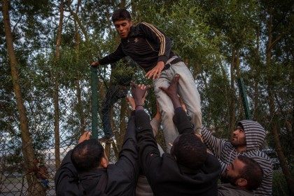 People help a man climb a fence (Rob Stothard/Getty Images)