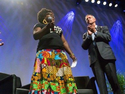Former Gov. Martin O'Malley (D-MD) (R), and moderator Jose Antonio Vargas (R), listen to Tia Oso, the National Coordinator for the Black Immigration Network, during an interruption to O'Malley's speech, at the Netroots Nation 2015 Presidential Town Hall with at the Phoenix Convention Center July 18, 2015 in Phoenix, Arizona. …