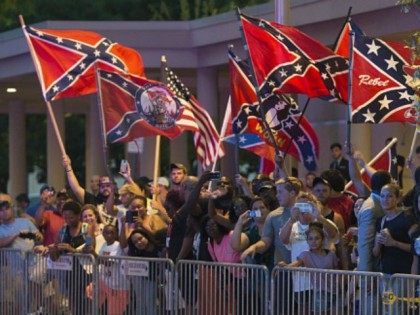 People wave Confederate Flags as US President Barack Obama arrives at his hotel in Oklahom
