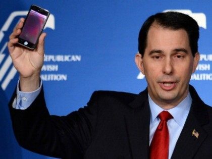 Wisconsin Gov. Scott Walker holds up his cell phone as he speaks during the Republican Jewish Coalition spring leadership meeting at The Venetian Las Vegas on March 29, 2014 in Las Vegas, Nevada. The Republican Jewish Coalition began its annual meeting with potential Republican presidential candidates in attendance, along with …
