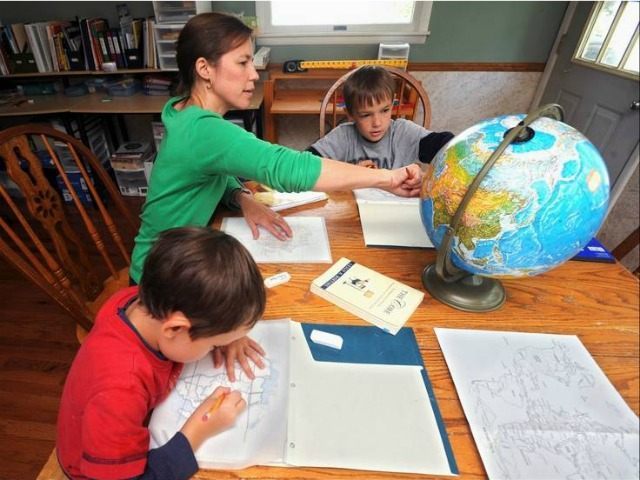 In this Aug. 24, 2012 photo, Elizabeth Boggs works with her sons Nathan, right, and Luke, left, with mapping and geography at her home in Charleston, Ill. Boggs is a member of the East Central Illinois Home Educator’s Network, a homeschool support group with more than 40 member families. (AP …