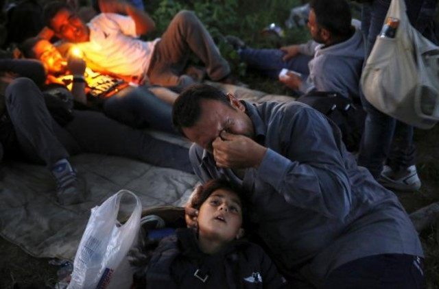 Kurdish Syrian immigrant Sahin Serko cries next to his 7 year-old daughter Ariana minutes