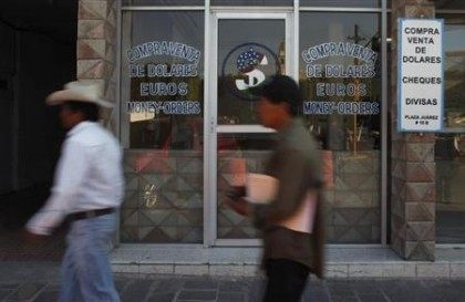Resident walks past a currency exchange business in the town of Ixmiquilpan