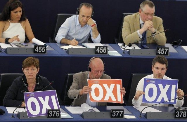 Members of the European Parliament hold posters with the word "No" (Oxi in Greek) during a