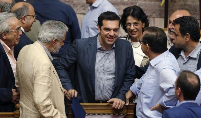 Greek Prime Minister Alexis Tsipras is congratulated by lawmakers after a voting session a