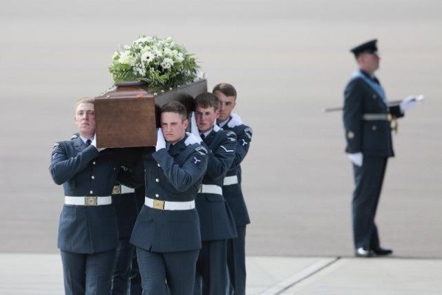 The coffin of David Thompson is carried from an RAF C-17, which repatriated the bodies of