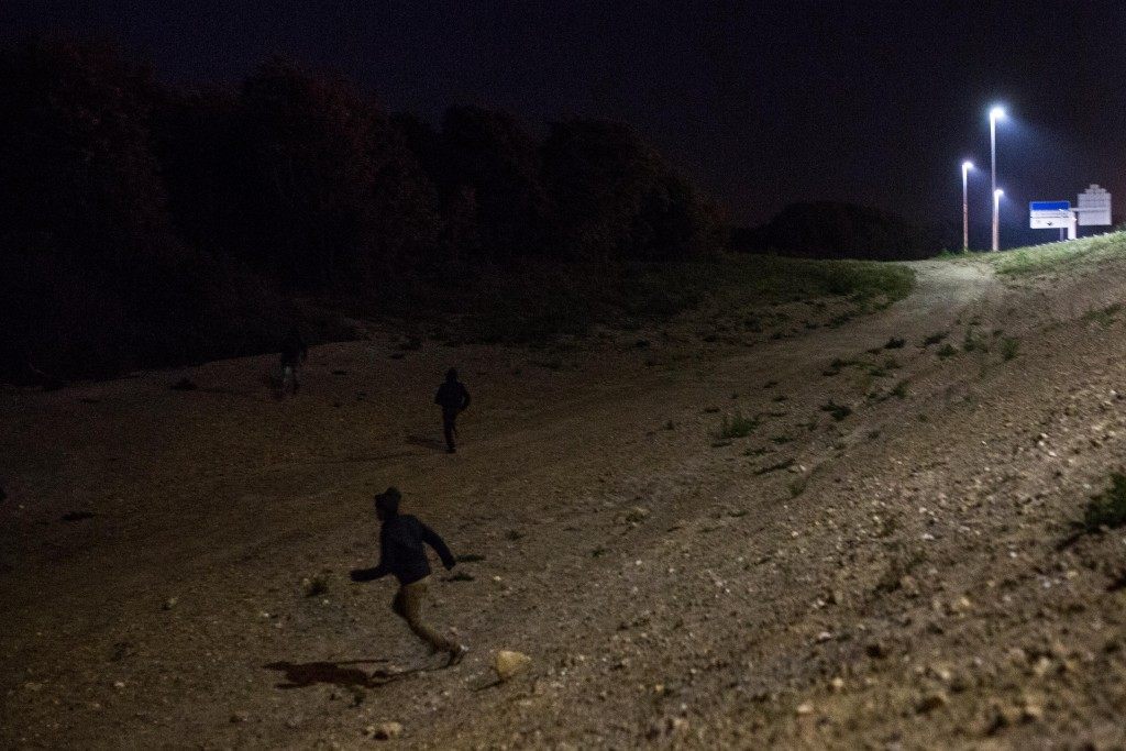 People run down a bank near the Eurotunnel terminal (Rob Stothard/Getty Images)