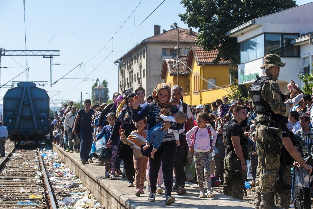 Migrants walk on a platform at the train station in the town of Gevgelija, on the Macedonian-Greek border, as they try to board trains to Serbia (ROBERT ATANASOVSKI/AFP/Getty Images)