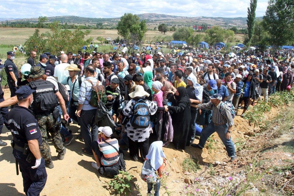 Migrants from Syria, Iraq and Afghanistan wait enter a temporary center for migrants in Serbia on the border between Serbia and Macedonia near the village Miratovac, in the municipality of Presevo (SASA DJORDJEVIC/AFP/Getty Images)