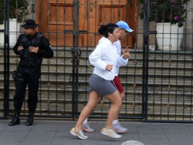 Joggers pass the Presidential residence in Guatemala city on August 27, 2015.