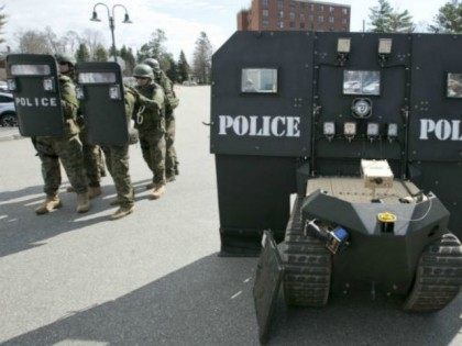 ﻿Police stand next to a SWAT robot in Sanford, Maine, during a media demonstration.