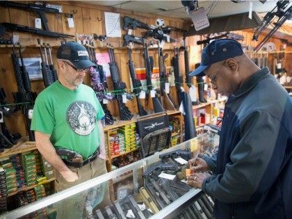 UNITED STATES, Tinley Park : TINLEY PARK, IL - MARCH 11: Danny Egan (L) helps a customer shop for a handgun at Freddie Bear Sports on March 11, 2015 in Tinley Park, Illinois. According to a survey conducted by the University of Chicago 32 percent of Americans own guns, down …