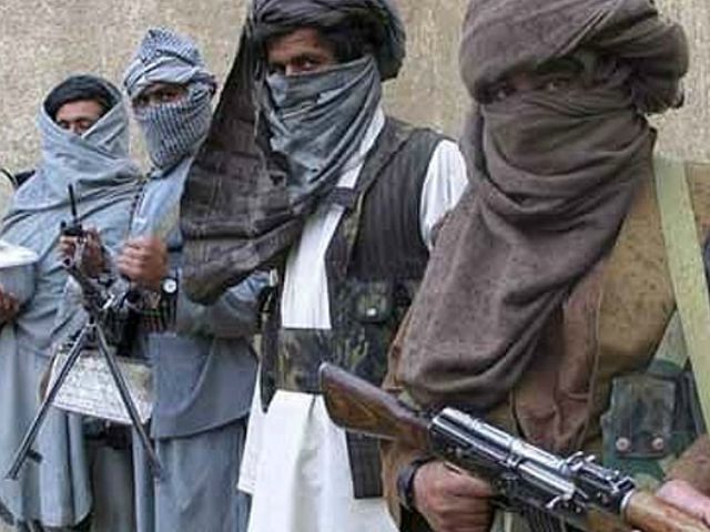 Taliban guerrilla fighters hold their weapons at a secret base in eastern Afghanistan in t
