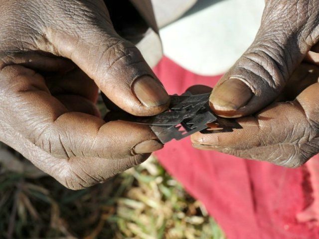 Prisca Korein, a 62-year-old traditional surgeon, holds razor blades before carrying out female genital mutilation on teenage girls from the Sebei tribe in Bukwa district, about 357 kms (214 miles) northeast of Kampala, December 15, 2008. REUTERS/JAMES AKENA/FILES