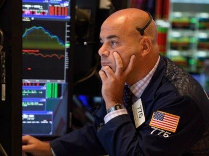 A trader on the floor of the New York Stock Exchange reads from his monitor August 24, 201