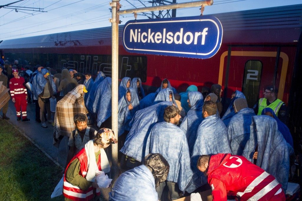 Migrants board a train in the village of Nickelsdorf (JOE KLAMAR/AFP/Getty Images)