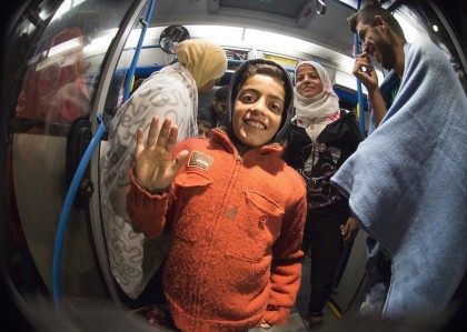 Migrants smile standing in a bus upon arrival at the village of Nickelsdorf (JOE KLAMAR/AF