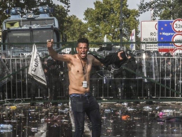 A migrant reacts after Hungarian riot police use water cannon to push back migrants (ARMEN