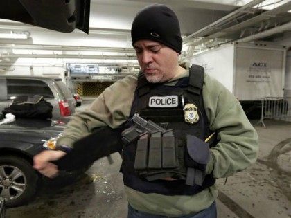 In this March 2, 2015 photo, an Immigration and Customs Enforcement officer "tacs up" in the garage of a New York federal building, as he prepares for series of early-morning arrests. Immigrant and Customs Enforcement say an increasing number of cities and counties across the United States are limiting cooperation …