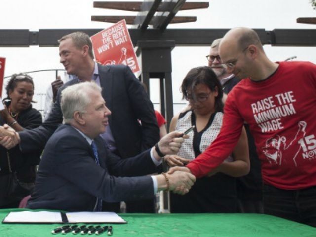 Seattle Mayor Ed Murray (C) celebrates with supporters and hands out ceremonial pens after