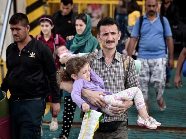A Syrian family disembarks from the Greek government chartered Eleftherios Venizelos ferry