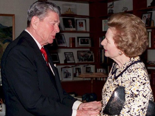 Former US President Ronald Reagan (L) shakes hands