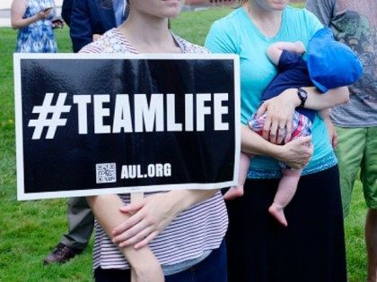 Anti-abortion activists hold a rally opposing federal funding for Planned Parenthood in fr