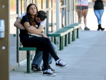 Friends and family wait for students at the local fairgrounds after a deadly shooting at U